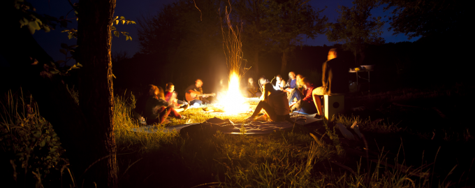 People gathered around an evening campfire